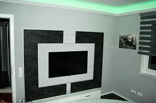 Wohnzimmer mit Wandgestaltung in Schwarz-Weiß und indirekter Beleuchtung