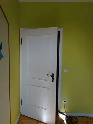 Grün gestrichene Wand mit weiß lackierter Zimmertür