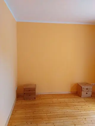 Zimmer mit Wänden in warmem Orange, frisch gestrichen